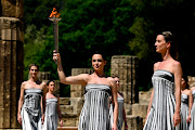 Greek actress Mary Mina, playing the role of the High Priestess, holds the torch during the dress rehearsal for the flame-lighting ceremony for the Paris 2024 Summer Olympics at the Ancient Olympia archeological site, birthplace of the ancient Olympics in southern Greece in Olympia, Greece on Monday.