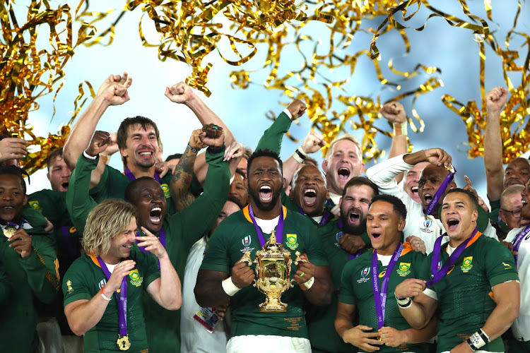 South African team members celebrate as Siya Kolisi lifts the Web Ellis Cup following their victory against England in the Rugby World Cup 2019 Final.