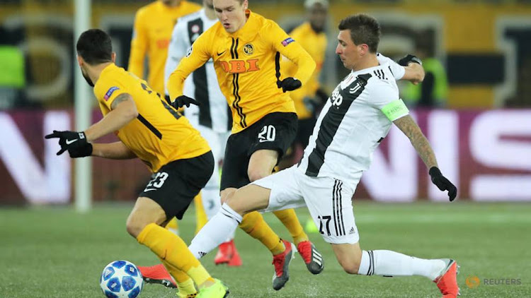 Juventus' Mario Mandzukic in action with Young Boys' Michel Aebischer and Loris Benito