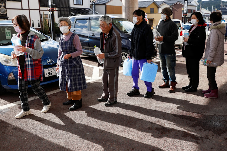 Evacuees stand in a line to receive water from a water tank car at an evacuation center, in the aftermath of an earthquake, in Wajima, Japan on January 4 2024. Picture: REUTERS/Kim Kyung-Hoon