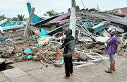 People look at a damaged hospital building following an earthquake in Mamuju, West Sulawesi province, Indonesia, January 15, 2021.  