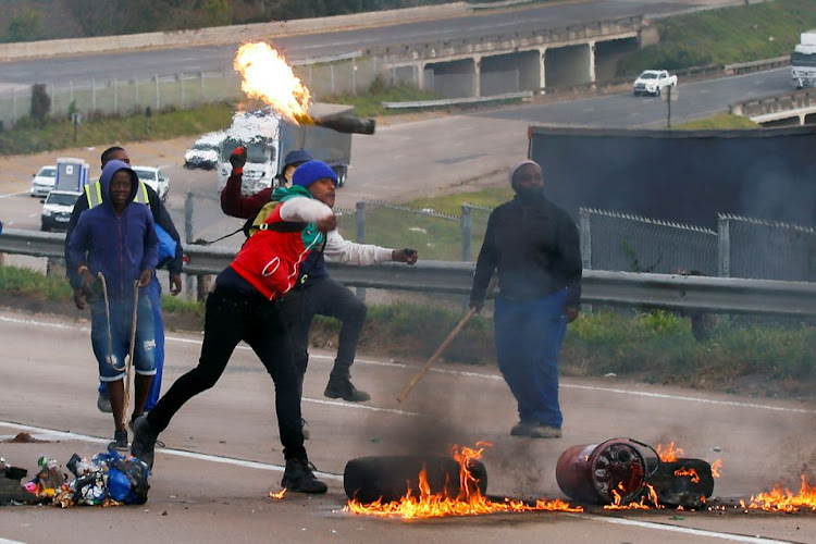 Supporters of former South African President Jacob Zuma block the freeway with burning tyres during a protest in Peacevale, South Africa, July 9, 2021. REUTERS/Rogan Ward/File Photo/File Photo