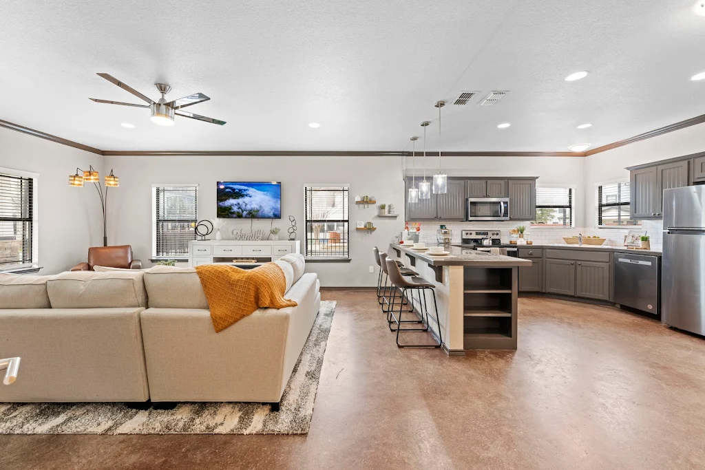 Model kitchen with neutral color scheme, pendant lights, peninsula