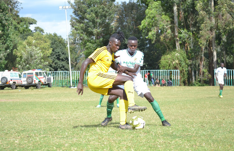 Silibwet Leons player Evans Kipkemoi (in yellow) tries to go past Mara Sugar FC player Drona Langa(in white) during the mid-week National Super League match at Silibwet Stadium on June 12, 2023.