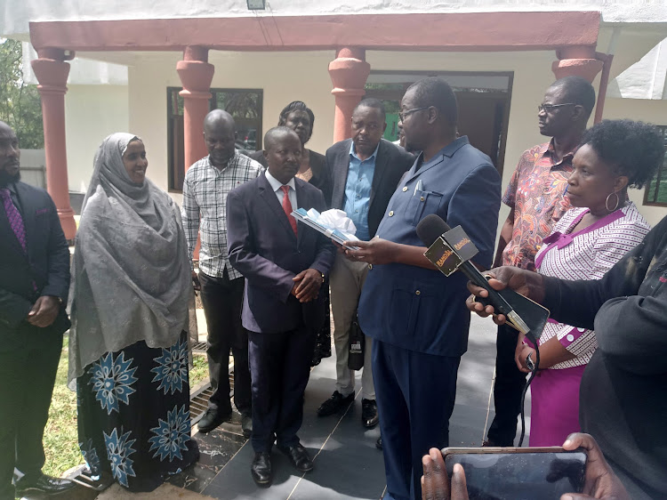 Migori Governor Ochillo Ayacko (wearing a blue kaunda suit) when he received the audit report.