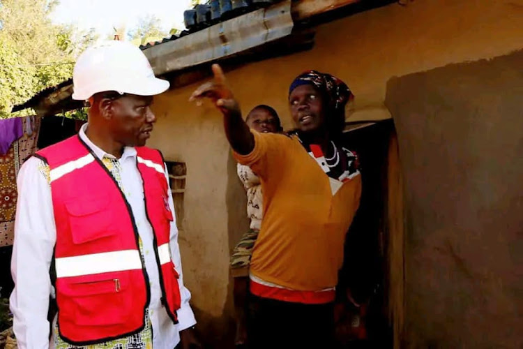 Uasin GIshu governor Dr Jonathan Bii visiting a family affected by floods at Cheptiret area