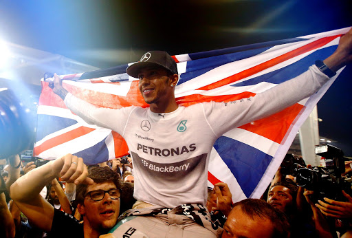 ABU DHABI, UNITED ARAB EMIRATES - NOVEMBER 23: (EDITORS NOTE: Retransmission of #459457336) Lewis Hamilton of Great Britain and Mercedes GP celebrates with his team after winning the World Championship after the Abu Dhabi Formula One Grand Prix at Yas Marina Circuit on November 23, 2014 in Abu Dhabi, United Arab Emirates. (Photo by Clive Rose/Getty Images)