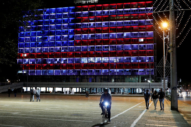 People walk by as the municipality building in Tel Aviv is lit in the colours of the American flag in solidarity with the victims of the Pittsburgh synagogue attack, Israel October 27, 2018 REUTERS/Nir Elias