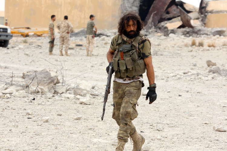 A member of Libya's internationally recognised government holds his weapon after taking control of Watiya airbase, southwest of Tripoli, Libya on May 18, 2020. Eastern Libyan forces pulled out of parts of Tripoli overnight, after they lost one of their major strongholds in western Libya on Monday.