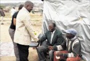 PEACE HANDSHAKE: Mpumalanga Premier David Mabuza greets Robert Hlophe and Elias Kubayi who have
settled at Msholozi informal settlement, outside White River. Pic:  ANDREW HLONGWANE. © Sowetan.