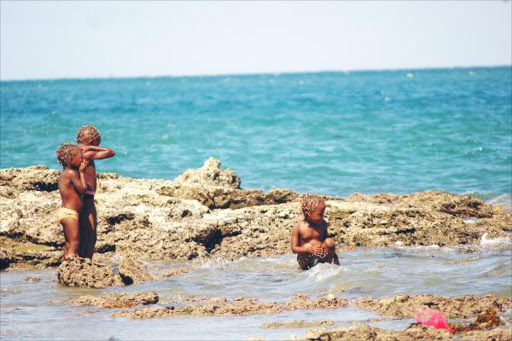 COOLING OFF: Children take a dip on the shores of the Indian Ocean.