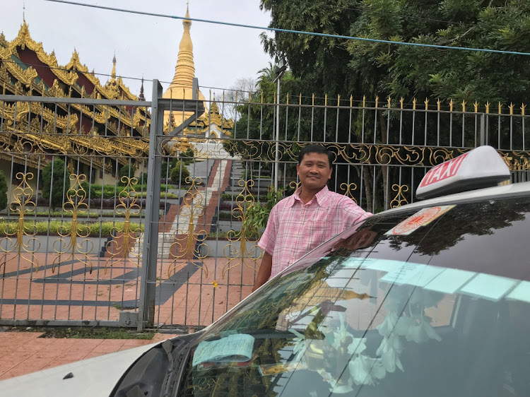 Taxi driver Ko Naing poses in front of Shwedagon Pagoda in Yangon, Myanmar, on October 9, 2020.