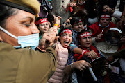 A police officer tries to detain the supporters of the women's wing of India's main opposition Congress Party during a protest against what they say is rising inflation in the country, in New Delhi on November 30 2021. File photo.