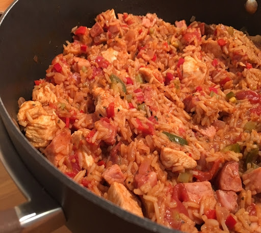 Rice with chicken, ham and sausage in a large skillet.