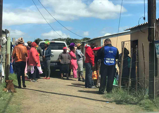 Community Members, Police and the Crime Scene Investigators at the home of the child who was run over by a minibus.