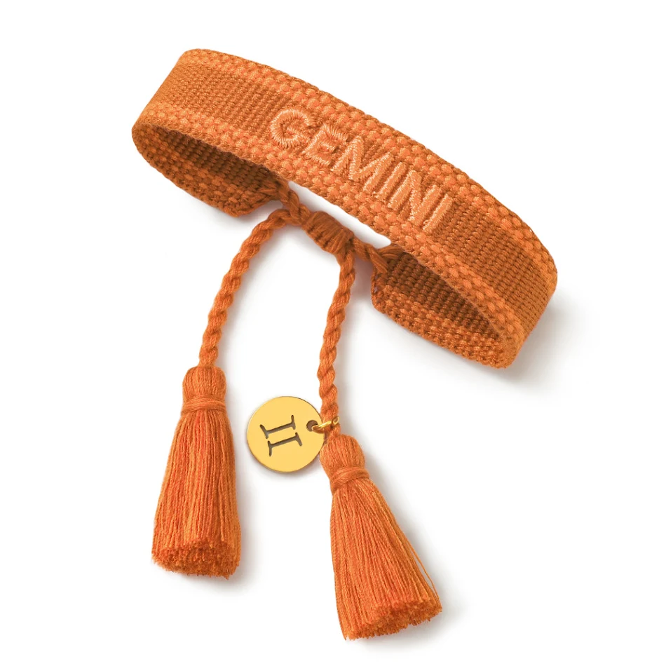 Armband mit zwölf Sternbildern, gestickten Buchstaben und gewebtem Handriemen. Dein Sternzeichen als modisches Accessoire.