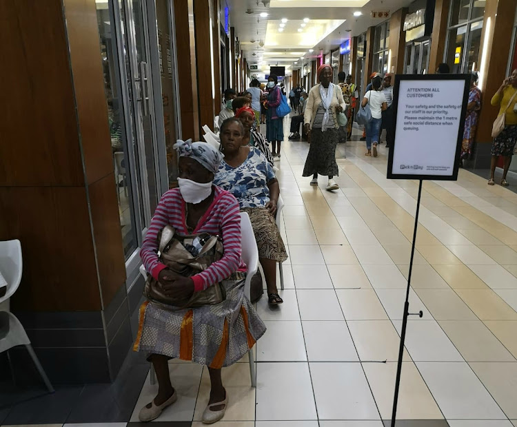 Sassa grant recipients queue in a corridor at Musgrave Centre in Durban. Recipients waited on chairs set 1m apart.