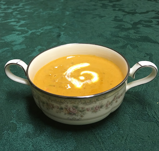 Lobster bisque with cream garnish, ready for serving.