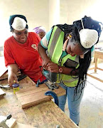 Carpenter Thembisile Sambo, right,  remains hands-on at work despite  additional carpenters she  hired as  her business grew.