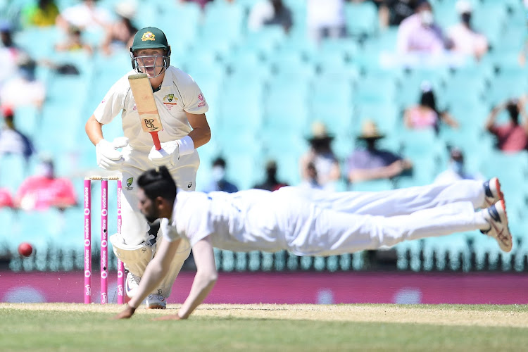 Marnus Labuschagne of Australia looks on as Mohammed Siraj of India dives for the ball during day four of the third test match between Australia and India at the SCG, Sydney, Australia