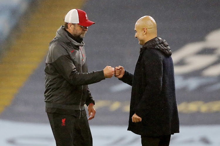 Manchester City manager Pep Guardiola and Liverpool manager Jurgen Klopp bump fists