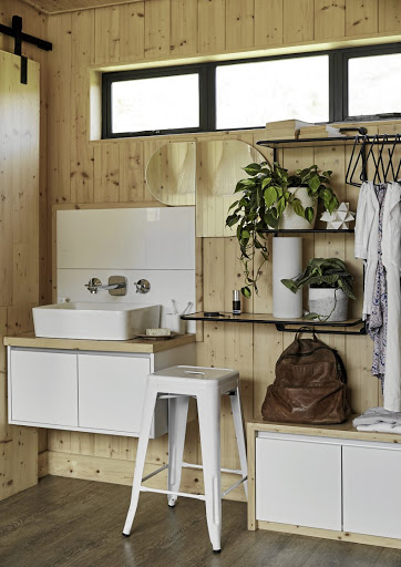 The main bedroom includes a basin and open storage. The windows above the basin play with perception and reflection.