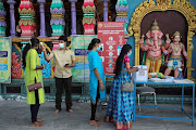 A worker checks the temperature of a devotee outside a temple, during the Hindu festival of Diwali amid the coronavirus disease outbreak in Kuala Lumpur, Malaysia on November 14 2020. 