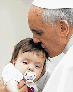 Pope Francis, blessing a baby at the Vatican yesterday, has slammed the loss of innocent life in the Bangladeshi factory fire