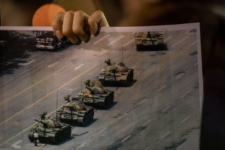 A demonstrator holds a photograph of the ’Tank Man’ scene at Victoria Park to commemorate the 31st anniversary of the Tiananmen Square crackdown, in Hong Kong, on June 4 2020. Picture: BLOOMBERG/PAUL YEUNG