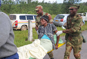 A woman is carried on a stretcher after being carried by a helicopter in Chimanimani, Zimbabwe. The Zimbabwean government said that nearly 100 people have died, with more than 200 others missing.