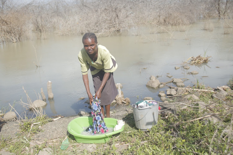 A woman washing her clothes on the shore of flooded lake Baringo on Saturday.