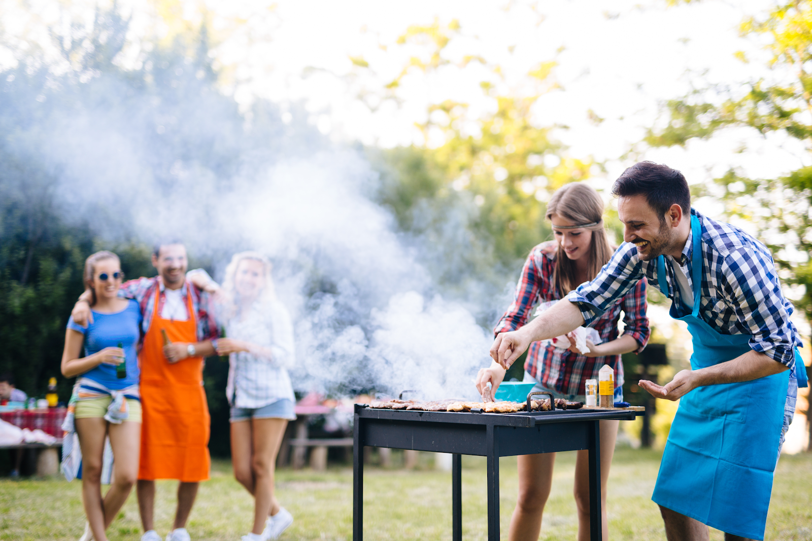 A family enjoys the outdoors while the father cooks on a grooved outdoor griddle