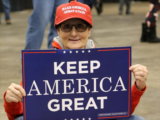 A supporter of US President Donald Trump sits on the floor with a "Keep America Great" sign at his rally in support of Ohio Republican candidates on the eve of the US midterm election in Cleveland, Ohio, US, November 5, 2018. /REUTERS