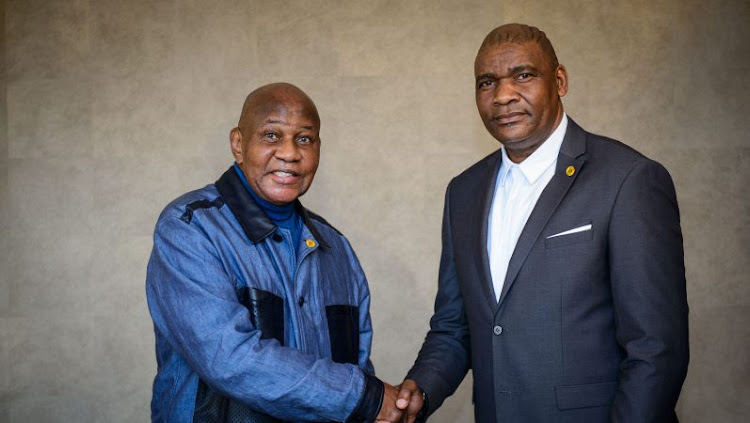 Kaizer Chiefs owner-chairman Kaizer Motaung (L) shakes hands with Molefi Ntseki (R).