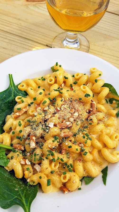 Of Roots and Blooms pops up every Wednesday at Bottles on Fremont and Sundays at Culmination Brewing offering rotating vegan delights. This Of Roots and Blooms vegan food example is their IPA Mac and Cheese, made with Culmination's Phaedrus IPA and topped with rushed pretzels and chives