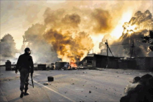 A policeman patrols a road during a service-delivery protest in Zandspruit, north of Johannesburg. File picture.