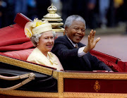 Nelson Mandela is accompanied by Britain's Queen Elizabeth II in a carriage ride to a Buckingham Palace lunch during his state visit to Britain in 1996.  