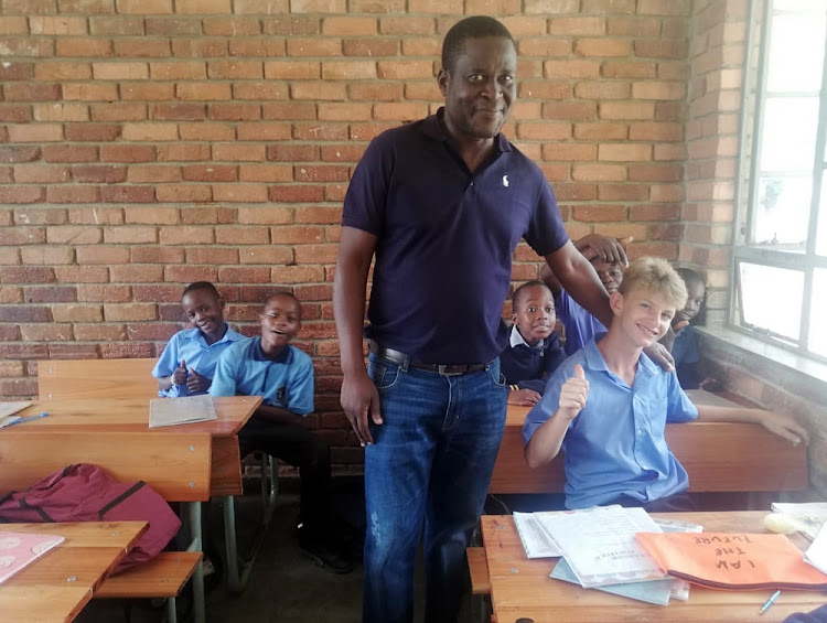 Dillin du Preez is the first white pupil at Nkowankowa Primary School outside Tzaneen. Teacher Lawrence Shingane with Dillin in the grade 6 classroom.