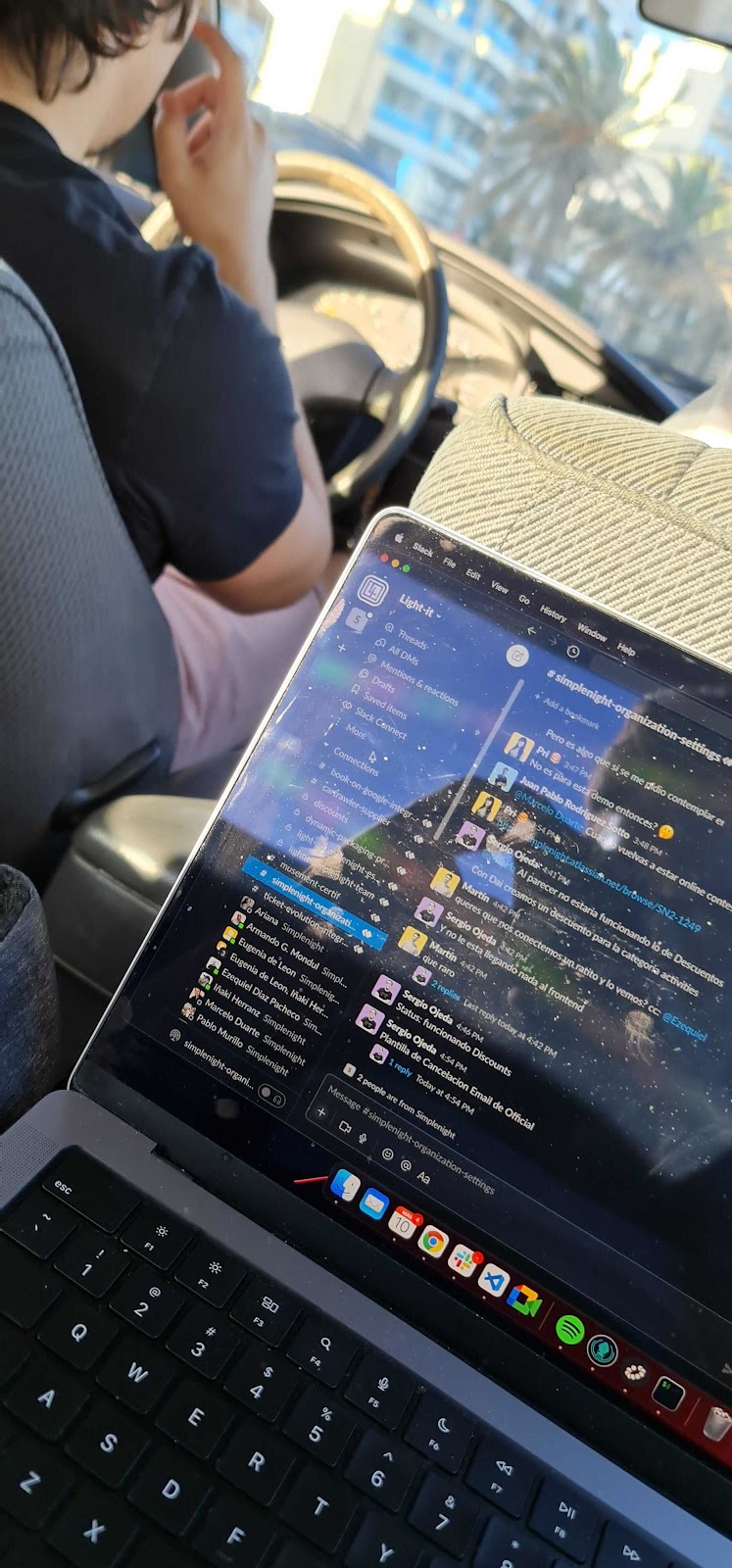 A collaborator working on his laptop from a car.