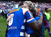 Rachel Kolisi hugs his husband Siya after a Super Rugby match. 