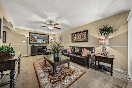 Cozy apartment living room with sofa, coffee table, and decorative elements, under warm lighting.