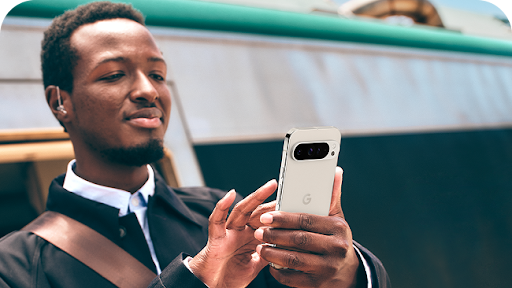 Image of a man scrolling through his Google pixel phone.