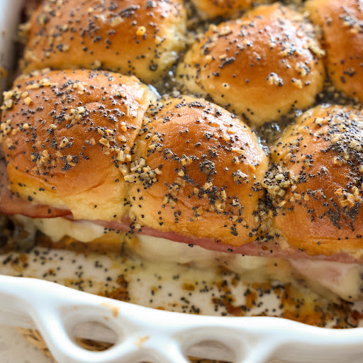 Quick and easy Ham and Cheese Sliders baked with a generous helping of honey butter seasoned with minced onion, poppy seeds, and Dijon mustard. 