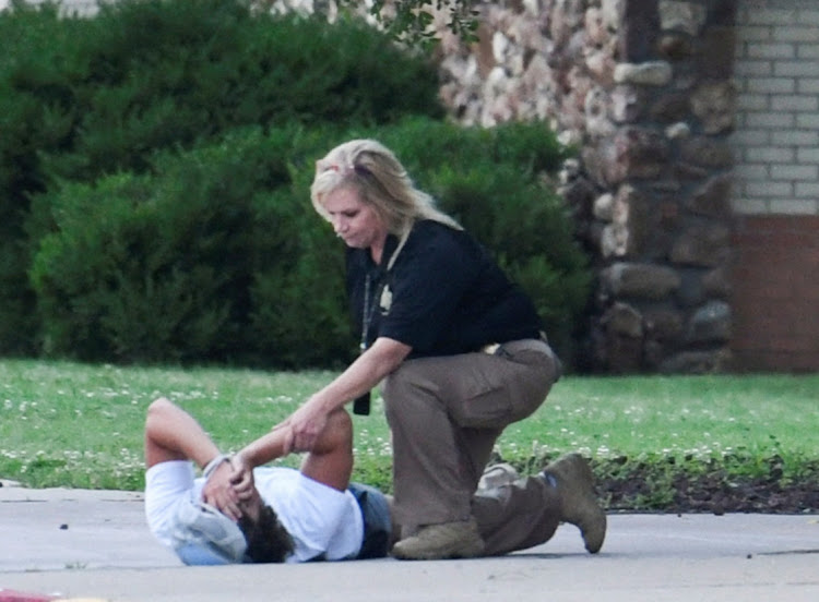 A police officer consoles a person at the family reunion location, Memorial High School, after a shooting at the Saint Francis hospital campus, in Tulsa, Oklahoma on June 1, 2022.