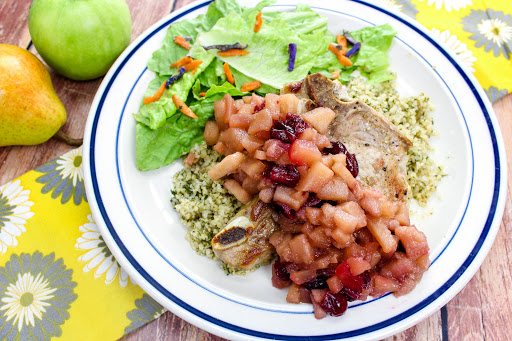 Apple and pear chutney spooned over pork chops.