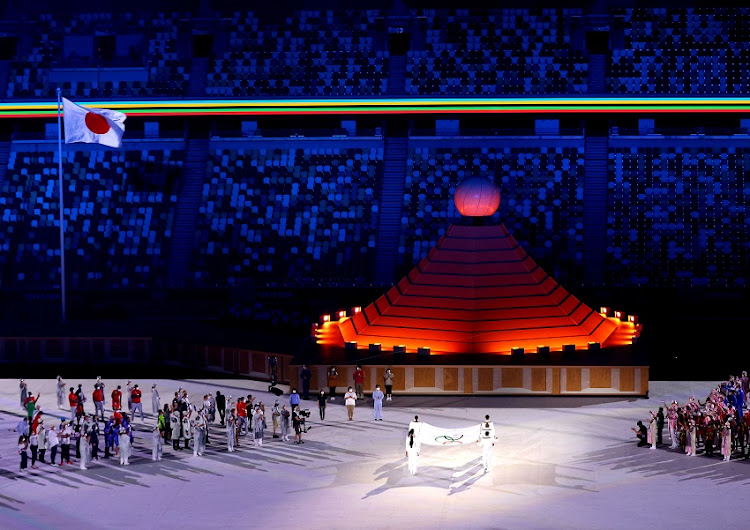 The Olympic flag is carried towards the Olympic cauldron during the Opening Ceremony of the Tokyo 2020 Olympic Games at Olympic Stadium on July 23, 2021 in Tokyo, Japan.