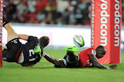 Lions' Madosh Tambwe (R) is tackled by Reds' James Tuttle (L) during the Super Rugby match at Ellis Park rugby stadium on March 18, 2017 in Johannesburg.