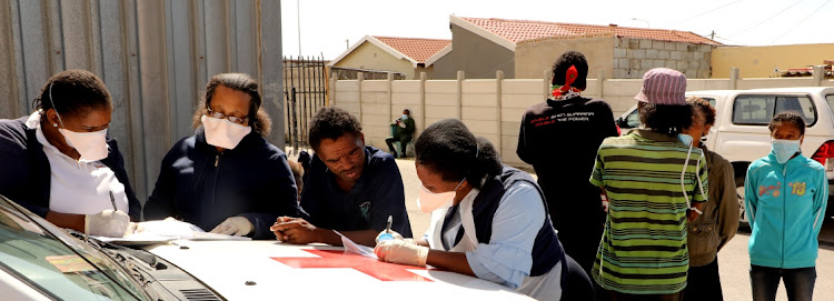 KEEPING TABS: A man is screened by health professionals at Daku Hall in Kwazakhele, one of the venues the municipality is using to house Nelson Mandela Bay’s homeless people