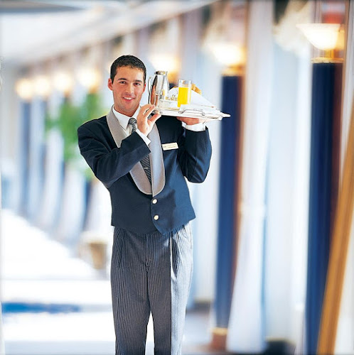 A smart-looking butler delivers breakfast on a Crystal cruise. 