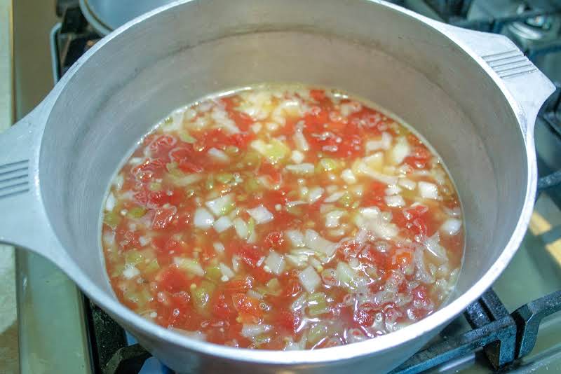 Broth, Tomato, Onion, Chiles, And Garlic In A Dutch Oven.